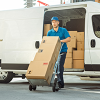 a person using a push trolley to move three parcels from an open van