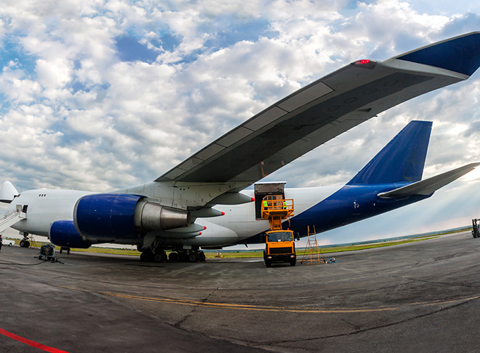 a blue and white cargo plane being unloaded from its hull